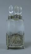 A set of three Continental silver mounted glass scent bottles in a silver stand. 15 cm high.
