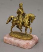 A 19th century gilt bronze of a gentleman on horseback, mounted on a rose quartz plinth base.