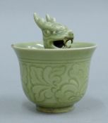A Chinese celadon porcelain dragon tea bowl. 9 cm high.