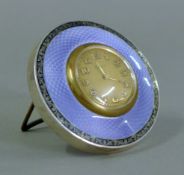 An enamel decorated silver desk clock. 8.5 cm diameter.