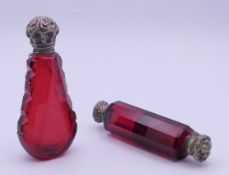 Two ruby glass silver-lidded scent bottles. 9.8 cm high and 10.5 cm high.