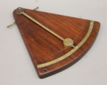 A brass and mahogany ship's inclinometer. 37 cm high.