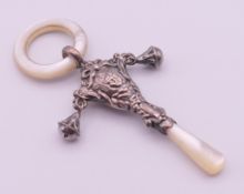 A silver and mother-of-pearl baby rattle with teething ring. 10.3 cm high.