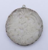 A pierced jade pendant. 5 cm diameter.