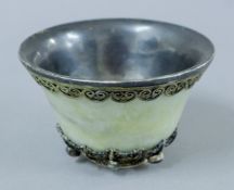 An Eastern unmarked white metal mounted stone cup set with various cabochons. 10 cm diameter.