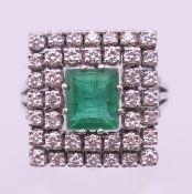 An 18 ct white gold, emerald and diamond ring. Setting 16 mm square, ring size Q. 9.