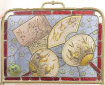 A Victorian brass-framed stained glass fire screen decorated with various birds,