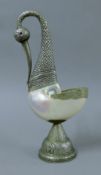 An Eastern unmarked white metal-mounted nautilus shell formed as a bird. 36 cm high.