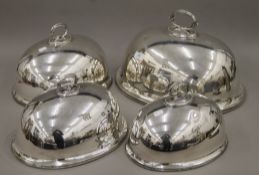 Four silver-plated meat covers. The largest 40 cm wide.