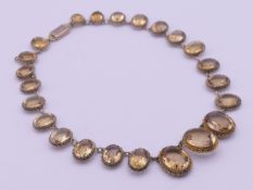 A silver gilt and citrine riviere necklace. 40 cm long.