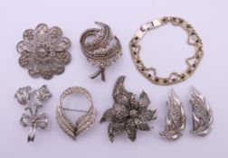A silver filigree flowerhead brooch, six other brooches and a bracelet. Filigree brooch 4.