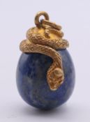 A silver gilt snake and lapis lazuli egg pendant bearing Russian marks.