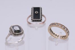 An unmarked eternity ring, a 9 ct gold and silver Art Deco ring, and a silver and marcasite ring.