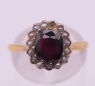 A 14 ct gold, garnet and seed pearl ring. Ring size K. 3 grammes total weight.