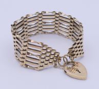 A 9 ct gold gate bracelet with padlock fastening. Bracelet 19 cm long, 2.5 cm high. 26.3 grammes.