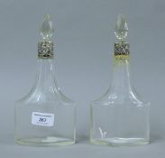 A pair of silver collared glass decanters. 23 cm high.
