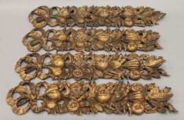 A set of four 19th century giltwood carvings of trailing fruit and swags. The largest 60 cm long.