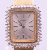 A Baylor 9 ct gold and diamond ladies' wristwatch on a 9 ct gold strap. Dial surround 2 x 2.3 cm.