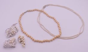 A quantity of pearl jewellery to include: two single strand necklaces and three brooches (two