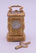 A gilt bronze figural miniature carriage clock with key. 7 cm high excluding handle.