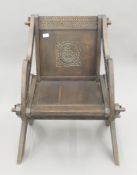 A 19th century carved oak Glastonbury chair. 84 cm high x 69 cm wide x 53 cm deep.