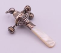 A silver and mother-of-pearl baby rattle. 10 cm high.