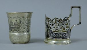 A Russian silver beaker decorated with townscape vignettes and a Russian silver niello cupholder.