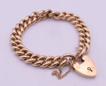 A 15 ct gold curb link bracelet with 15 ct gold padlock heart clasp. Links 1 cm high, 19 cm long.