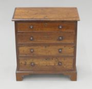 A mahogany miniature chest of drawers. 25 cm high x 23 cm wide.