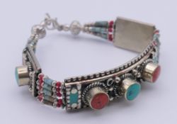 A Tibetan white metal, coral and turquoise bracelet. 19 cm long, 1.5 cm high.