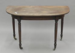 A late Georgian mahogany D-end table on turned legs. 118 cm wide.
