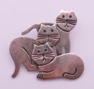 A silver brooch of three stylised cats. 3.5 cm high.
