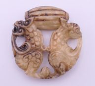 A jade roundel carved with pixiu dragons. 5.5 cm diameter.