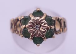 A 9 ct gold and emerald daisy ring. Ring size M. 3.1 grammes total weight.