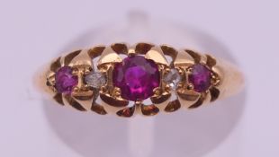 An 18 ct gold ring set with three synthetic rubies. Ring size M/N. 2.8 grammes total weight.