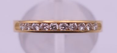 An 18 ct gold channel set diamond ring. Ring size N. 2.7 grammes total weight.
