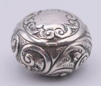 An embossed silver pill box. 4 cm diameter.