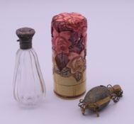 Three lidded scent bottles, one glass scent bottle enclosed within a screw top floral cylinder.