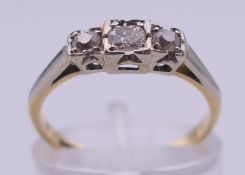 An 18 ct gold and platinum three-stone diamond ring. Ring size K. 2.1 grammes total weight.