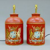 A pair of red toleware lamps. Each 45 cm high.
