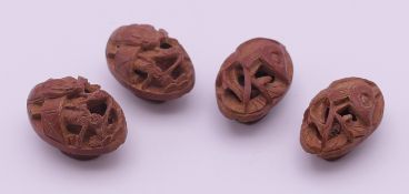 Four carved peach stone buttons. Each approximately 2.5 x 1.5 cm.