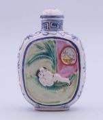 A Chinese porcelain snuff bottle and stopper decorated with an erotic scene. 7 cm high.