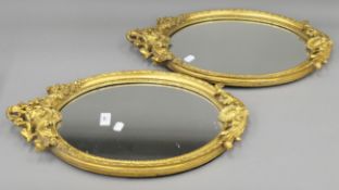 A pair of decorative gilt-framed mirrors. Each 51.5 cm high.