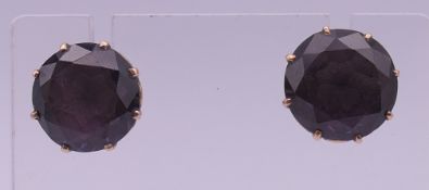 A pair of purple stone earrings with 14 K gold butterfly backs. 12 mm diameter.