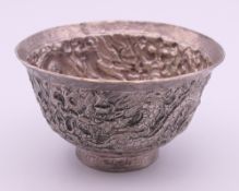 A Chinese unmarked white metal bowl decorated with dragons. 8 cm diameter.