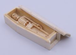 A carved bone model of a coffin enclosing a skeleton. Coffin 11.5 cm high.