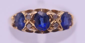 An 18 ct gold blue and clear stone ring. Ring size N. 2 grammes total weight.