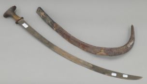 An Ethiopian curved bladed sword with horn handle in embossed leather scabbard. 94 cm long x 3.