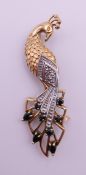 A 9 ct gold, diamond and sapphire peacock form brooch. 5 cm high. 4.5 grammes total weight.