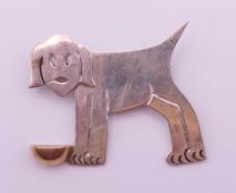 A silver dog with bowl brooch. 4 cm high.